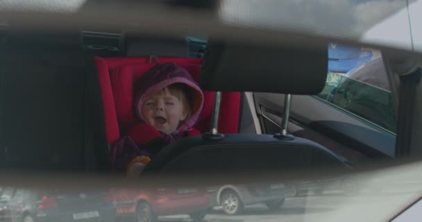 Söt liten flicka gäspar sött i en bilstol. Schema för barnsömn — Stockvideo