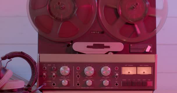 Carrete retro a carrete grabadora de cinta jugando en rojo. Reproductor de música vintage giratorio — Vídeos de Stock