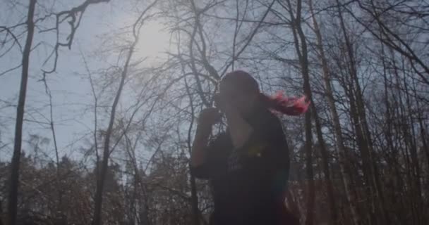 Сонячне світло на гілках дерев. Крупним планом руки і голова дівчина тіней тренування боксу — стокове відео
