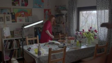 Ev sanatları stüdyosunda hazırlanan bir kadın, her şeyi masaya koyuyor.. 