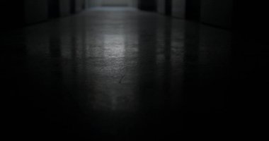 Kamera hareketi. Karanlık bir odada yerde bir ışık parlaması. Hareket halindeki ışığı kapatıyorum. Yüzeyde enkaz ve kir var. Kamera sallaması.