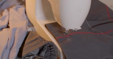 Pantolonuna kırmızı çizgiler dikmeyi bırak. Cihaz kumaşı düzeltti, beyaz iplik. Çalışırken duraklat, çalışanın geri kalanı. Kamera hareketi.