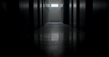 Uzun koridorlu karanlık bir oda. Tutuklular için bir sürü hücre kapısı var. Işık huzmesi hareket ediyor. Koridorun sonunda parlak bir pencere var..