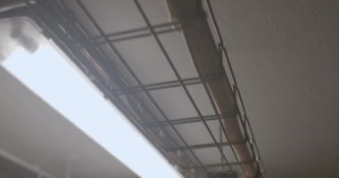 Binanın tavanının altına kablo ve kablolar bağlıyorum. İletişim kurmak için mühendislik tasarımı. Işığın ışığı, hareket.