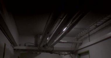 Fabrikanın teknik odası. Tavandaki ışığı yakmak, odayı aydınlatmak, tavandaki termal yalıtım boruları. Makine dairesi iletişimi. Koyu
