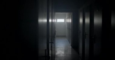 Kamera hareketleri karanlık koridor akıl hastanesini daraltıyor. Kapılarda ve yerde parlıyor. Tünelin sonundaki pencereden gelen ışık. Birçok oda kapısı kilitlendi. Tehlikeli insanların konumu.