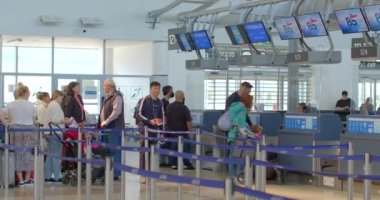 Resepsiyon grubundaki mavi dijital ekranlar havaalanı kuyruğunda. Turist davetiyesi bekliyorlar. Giriş için bekliyorlar. Omuz çantaları, el telleri. CZ, Prag, Aviaticka, 8.6.22.