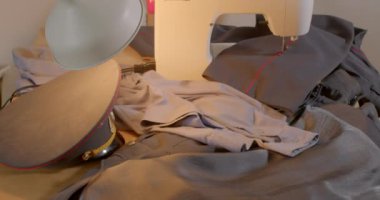 Dikiş makinesinde özel kıyafet terziliği. Kırmızı çizgili pantolon işçiler tarafından alınır. Dikiş Dükkanında Başlamak.