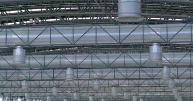 Metal bir yapının tavanındaki havalandırma sistemleri. Borular ve havalandırma kanalları. Büyük oda havalandırma sistemi. Metal parçaları için oruç tutmak. Hafif yapı.