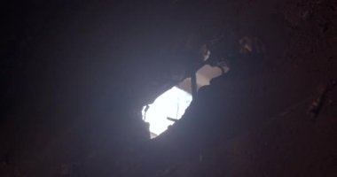 Beton bir duvarda kabuktan bir delik. Işık duvardaki bir delikten girer. Savaşın sonuçları, yıkılan bina. Çıkan demirler, tehlike ve korku..