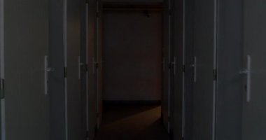 Binanın teknik odasının karanlık koridorunda kamera hareketi. Mülkün şahsi deposu. Karanlık bir odada bir dizi kapı..
