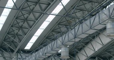 Yapılar, çeşitli alanlarda kullanılan metaller ve çeşitli alaşımlar yaptı. İnşaat binalarında ekonomik aktivite. Metal yapı elementleri taşıyan çelik bir bina. Tavandaki pencere aralıkları.