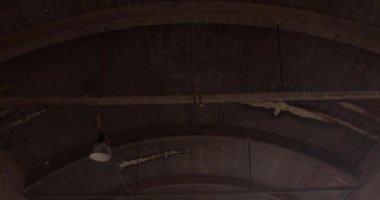 Endüstriyel bir binanın eski teknik odasında tavan hareketi. Tavandaki kasalar, aydınlatma cihazları kabloya bağlı. Karanlıktaki yüksek oda..