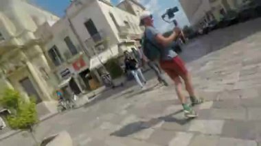 Genç bir blogcu çevrimiçi bir yayının kaydını bitirmek için jest yapıyor. O, mavi gökyüzüne karşı eli ile lensi kapatır. Yaz güneşi.