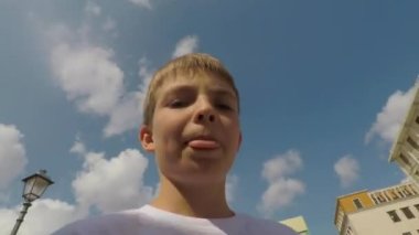 Video kaydetmek için aksiyon kamerası kullanıyor. Eski mimarinin arka planına karşı. Bir genç yazın seyahat ederken selfie çeker ve blog yazar.. 