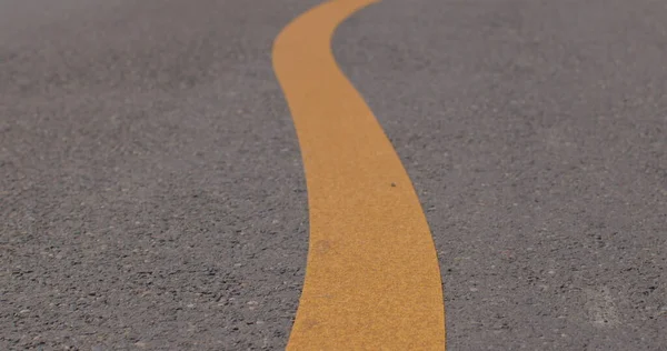 Orange line on the asphalt road. Curved drawing of markings on the road, traffic control. Offset markings on a hot day, melted paint.
