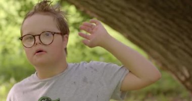 Yağmurdan sonra ıslak saçlı bir çocuğun portresi. O, eliyle kafasına dokunur. Gözlerde gözlük, gelişmiş görüş. Gülümse yüzüne, olumlu motivasyon.