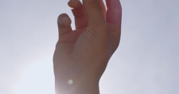 太陽の光を背景にした10代の若者の動き 彼は指のスナップ 抽象的な指の動きを作る 光の輝き 創造的な実現 — ストック動画