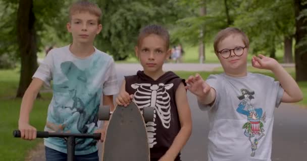 子供たちは街の公園でカメラを見てポーズ ダウン症候群の少年 違いにかかわらず 誰もが歓迎され 評価されるコミュニティを促すインクルージョン哲学 プラハ ストロモフカ — ストック動画