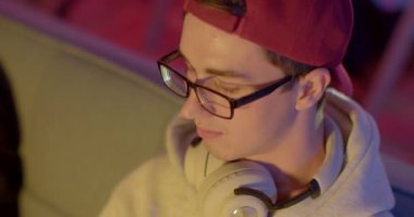 Vizyon rahatsızlığı. Portreci gözlük takar ve video oyunu kumandası kullanır. Gözün dikkati, yakın plan. Akşamları evde boş zaman aktiviteleri. CZ, Prag, Plzenska, 20.6.2022