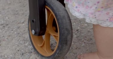 5 numara boyalı küçük bir çocuk için bisiklet gidonu. Çocuk direksiyona ve direksiyona eliyle dokunuyor. Tekerlekli taşıtla ilk tanışma. CZ, Kladno, Polska, 4.7.22