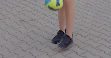 Bir gencin bacakları kaldırıma bir top dolduruyor. Topu kontrol etme yeteneğini arttırıyor. Bacak gücü ve koordinasyon. Çeviklik. CZ, Kladno, Polska, 4.7.22