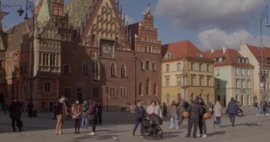 Eski bir Avrupa şehrinin sokaklarında bebek arabası olan turistler. Çocuklarla seyahat etmek. PL, Wroclaw, Bujwida, 18.2.22.
