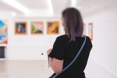 Resim galerisi açılışına katılan bir grup ziyaretçi, modern güzel sanatlar koleksiyonu sergisi, müze salonundaki resimli siluetler.