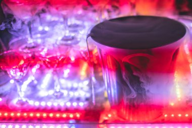 Bardaklar piramidi, alkollü içecekler, doldurma ve doldurma farklı renkte alkollü kokteyller ve bir partide kuru buz,