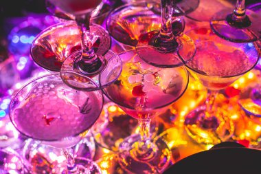 Bardaklar piramidi, alkollü içecekler, doldurma ve doldurma farklı renkte alkollü kokteyller ve bir partide kuru buz,