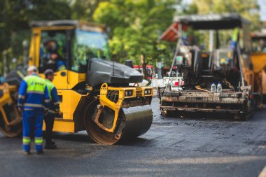 İnşaat ve onarım çalışmaları sırasında asfaltlama, asfalt kaldırım ve kaldırım, asfalt kaldırım makinesi ve buhar silindiri sıkıştırma, inşaat ve onarım çalışmaları, inşaat alanında çalışan işçiler, kiralık araç