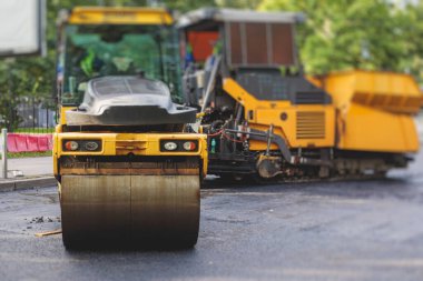 İnşaat ve onarım çalışmaları sırasında asfaltlama, asfalt kaldırım ve kaldırım, asfalt kaldırım makinesi ve buhar silindiri sıkıştırma, inşaat ve onarım çalışmaları, inşaat alanında çalışan işçiler, kiralık araç