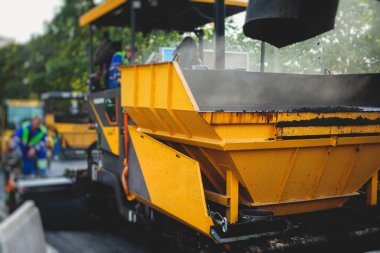 İnşaat ve onarım çalışmaları sırasında asfaltlama, asfalt kaldırım ve kaldırım, asfalt kaldırım makinesi ve buhar silindiri sıkıştırma, inşaat ve onarım çalışmaları, inşaat alanında çalışan işçiler, kiralık araç