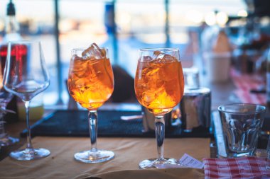 Bir gece kulübünün barında, martinide, votkada ve diğerleri açık havada bile dekore edilmiş ziyafet masasında farklı renkte kokteyller içen güzel bir barmenin önünde.