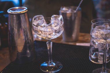 Bir gece kulübünün barında, martinide, votkada ve diğerleri açık havada bile dekore edilmiş ziyafet masasında farklı renkte kokteyller içen güzel bir barmenin önünde.