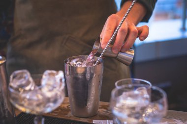 Bir gece kulübünün barında, martinide, votkada ve diğerleri açık havada bile dekore edilmiş ziyafet masasında farklı renkte kokteyller içen güzel bir barmenin önünde.