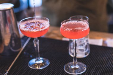 Bir gece kulübünün barında, martinide, votkada ve diğerleri açık havada bile dekore edilmiş ziyafet masasında farklı renkte kokteyller içen güzel bir barmenin önünde.