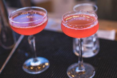 Bir gece kulübünün barında, martinide, votkada ve diğerleri açık havada bile dekore edilmiş ziyafet masasında farklı renkte kokteyller içen güzel bir barmenin önünde.