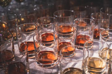 Bir partide, viski, viski, viski, viski, viski, konyak, brendi ve diğer kokteyller, bardaki tezgahta duran bardaklar.