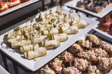 Yemek masası, çeşitli yiyeceklerle süslenmiş güzel bir ziyafet. Kurumsal doğum günü partisi etkinliği ya da düğün kutlaması için aperatifler. Deniz ürünleri, kanepe, şarküteri.