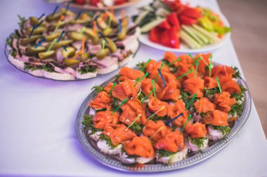 Yemek masası, çeşitli yiyeceklerle süslenmiş güzel bir ziyafet. Kurumsal doğum günü partisi etkinliği ya da düğün kutlaması için aperatifler. Deniz ürünleri, kanepe, şarküteri.