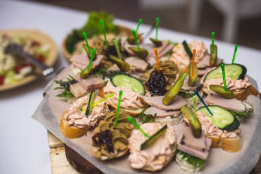 Yemek masası, çeşitli yiyeceklerle süslenmiş güzel bir ziyafet. Kurumsal doğum günü partisi etkinliği ya da düğün kutlaması için aperatifler. Deniz ürünleri, kanepe, şarküteri.