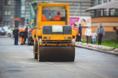 İnşaat ve onarım çalışmaları sırasında asfaltlama, asfalt kaldırım ve kaldırım, asfalt kaldırım makinesi ve buhar silindiri sıkıştırma, inşaat alanında çalışan işçiler, kiralık araç kiralama