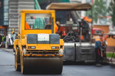 İnşaat ve onarım çalışmaları sırasında asfaltlama, asfalt kaldırım ve kaldırım, asfalt kaldırım makinesi ve buhar silindiri sıkıştırma, inşaat alanında çalışan işçiler, kiralık araç kiralama