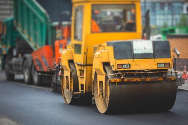 İnşaat ve onarım çalışmaları sırasında asfaltlama, asfalt kaldırım ve kaldırım, asfalt kaldırım makinesi ve buhar silindiri sıkıştırma, inşaat alanında çalışan işçiler, kiralık araç kiralama