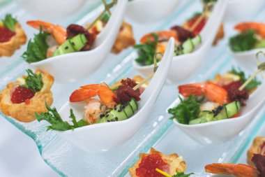 Yemek masası, çeşitli yiyeceklerle süslenmiş güzel bir ziyafet. Kurumsal doğum günü partisi etkinliği ya da düğün kutlaması için aperatifler. Deniz ürünleri, kanepe, canlı şarküteri seti.