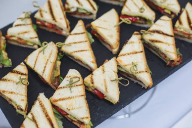 Yemek masası, çeşitli yiyeceklerle süslenmiş güzel bir ziyafet. Kurumsal doğum günü partisi etkinliği ya da düğün kutlaması için aperatifler. Deniz ürünleri, kanepe, canlı şarküteri seti.