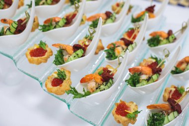 Yemek masası, çeşitli yiyeceklerle süslenmiş güzel bir ziyafet. Kurumsal doğum günü partisi etkinliği ya da düğün kutlaması için aperatifler. Deniz ürünleri, kanepe, canlı şarküteri seti.