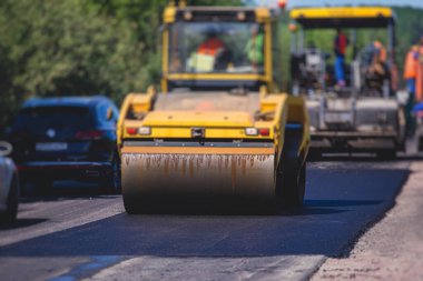 Asfaltlama ve asfalt kaldırım, asfalt kaldırım makinesi ve yol yapımı ve onarım çalışmaları sırasında buharlı yol silindiri, yeni yol inşaatında çalışan işçiler, yazın katman yerleştirme