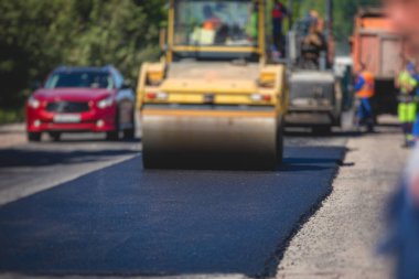 Asfaltlama ve asfalt kaldırım, asfalt kaldırım makinesi ve yol yapımı ve onarım çalışmaları sırasında buharlı yol silindiri, yeni yol inşaatında çalışan işçiler, yazın katman yerleştirme